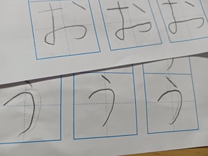 マスにひらがなの「お」と「う」を鉛筆で書いたプリントの写真