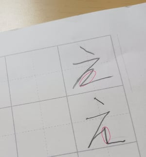 ガイドの目印の点に沿って書かれた改善された「え」の文字の写真