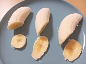 それぞれ皮を剥き斜めにカットして切り口が見えるように並べたバナナの写真