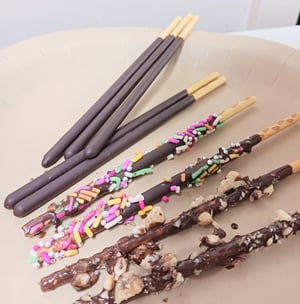 スプレチョコーやアラザンでデコレーションされたポッキーの写真