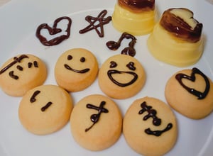 プリンと一緒にチョコレートでデコレーションしたクッキーを盛り付けたデザートプレートの写真