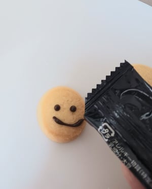 クッキーにチョコレートで絵を書いている写真