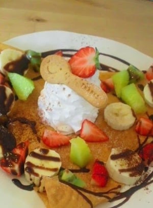 お店で食べたフルーツがたくさん乗っている包んでいないクレープの写真