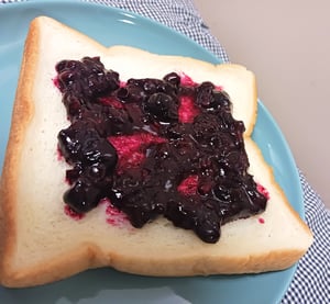 食パンに塗ったミックスベリージャムの写真