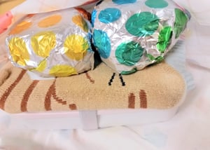 猫のイラストのペットボトルカバーに入った保冷剤におにぎりを重ねている写真
