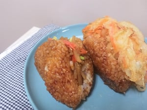 おにぎりに具材が挟まっている焼きおにぎりバーガーの写真