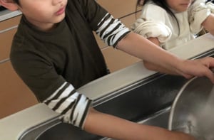 子どもが洗い物をする写真
